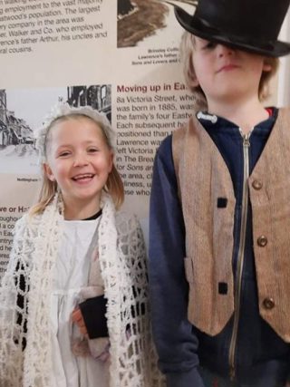A girl and boy dressed in Victorian clothing at the museum