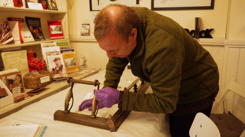 volunteer cleaning and item at the museum
