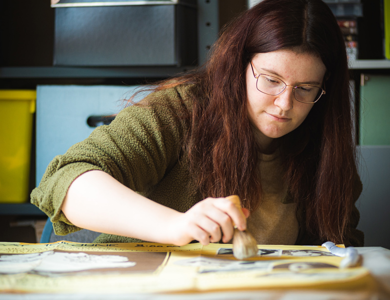 Volunteer cleaning an item at the museum