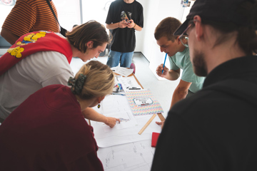 People gathered round a table looking at plans and discussing