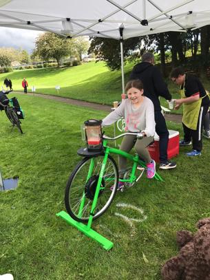 Child at Green Festival using Pulp Friction's smoothie bike