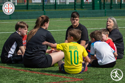 children sitting on the Stapleford Community Pavilion pitch