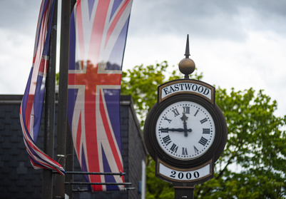 Clock in Eastwood Town Centre outside the library with a union jack flag