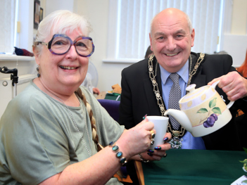 The Mayor pouring tea for a volunteer