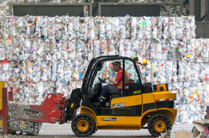 Forklift at Materials recovery facility placing recycling in a pile