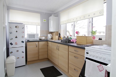 Modernised kitchen with cream coloured blinds and tiles