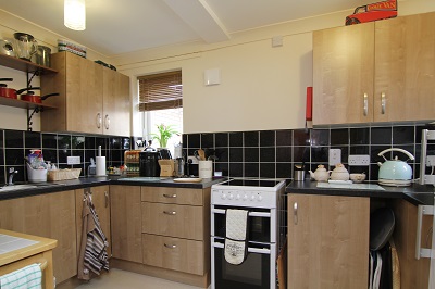 Modernised Kitchen with black tiles covering the lower half of the wall