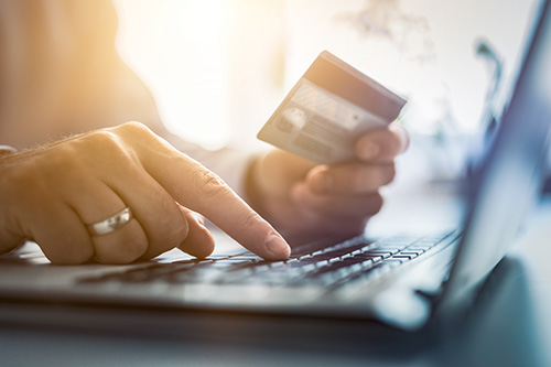 Person using their credit card to make a payment online using their computer