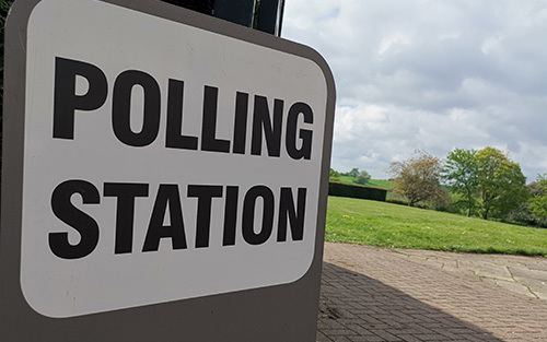Polling Station sign next to a field