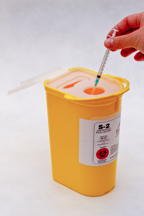 Needle being placed in a sharps bin