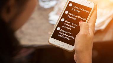 A woman holding a phone screen with some survey questions written on