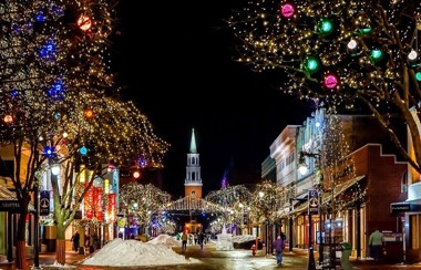 A town centre with snow and lit up in Christmas lights