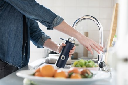 A man filling a reusable water bottle at the tap