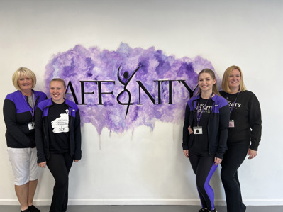 Four women stood in front of a sign affinity