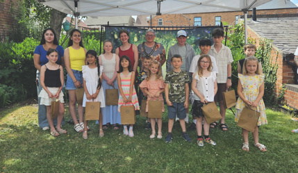 The winners of the children's writing competition in the museum garden with deputy mayor councillor Sarah Webb