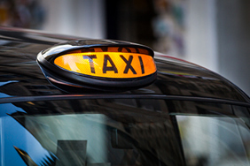 Illuminated taxi sign on top of London style cab