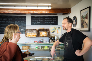 Owner of a sandwich shop talking to a customer in Eastwood
