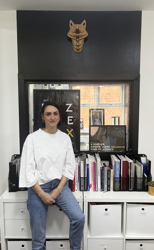 Fazane in her office in front of her rebranded logo