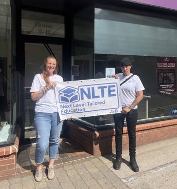 Sam and Ezrah in front of their new premises with Next Level Tailored Education branded banner