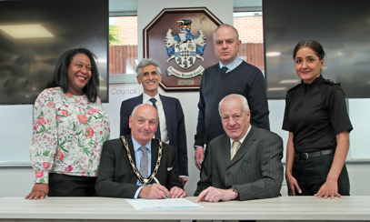 Senior leaders from Broxtowe, the Police, and Broxtowe MP Juliet Campbell signing the pledge in front of the Broxtowe crest in the council chambers